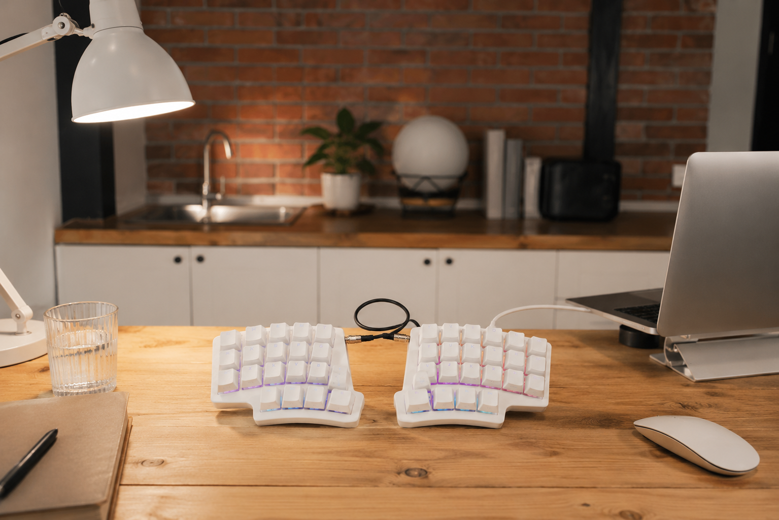 Split  keyboard  on a wooden desk with a bedroom in the background